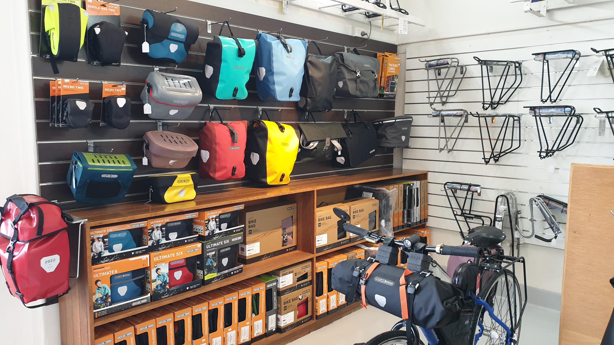 a wall of Ortlieb panniers & handlebar bags hanging in the Abbotsford Cycles shop