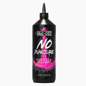 A tall 1Ltr bottle of Muc-Off No Puncture Tubeless Sealant is shown with dramatic pink graphics and a small black applicator nozzle