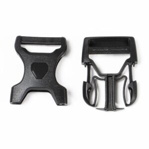A set of male & female ends of an Ortlieb Stealth Side Release Buckle are shown in black plastic on a white surface