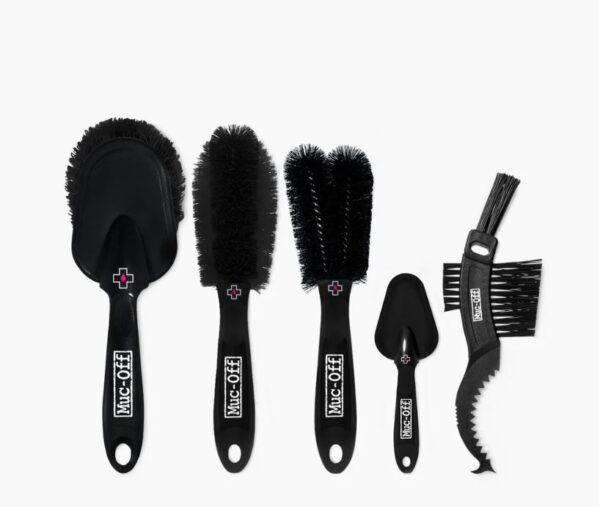 A Muc-Off 5x Premium Brush Set is shown with the 5 brushes laid out on a white surface