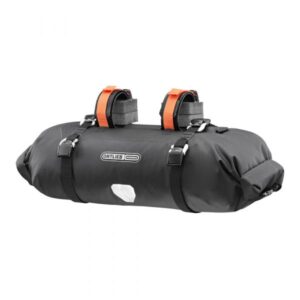 an Ortlieb Handlebar Pack is shown in a black waterproof fabric with spacers under the handlebar straps and oragne strapping over the top
