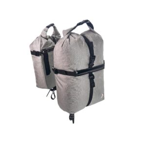 A pair of Revelate Nano Panniers are shown in grey sail cloth material designed for hanging off a rear rack while bikepacking
